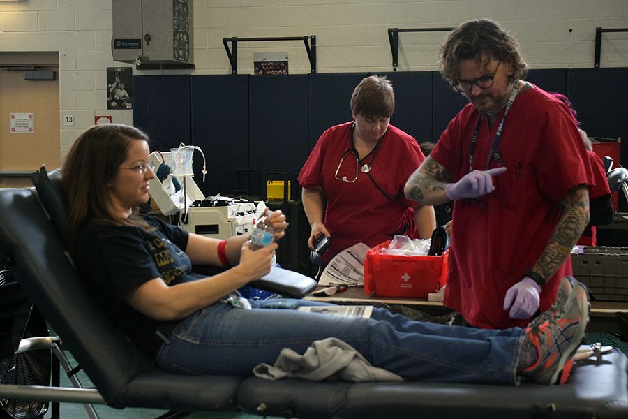 A blood drive volunteer explains to Mrs. Diamantopoulos what to be aware of after donating blood.
