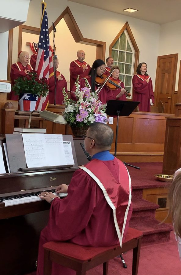 Natally Bisco (19) playing the violin at church while her father plays the piano.
