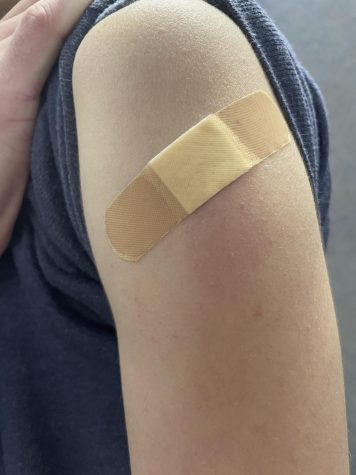 A student shows his arm after having received a flu vaccination.