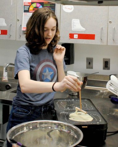 Jordyn Kelly (26) uses a spreader to cook crêpes on an electric griddle.