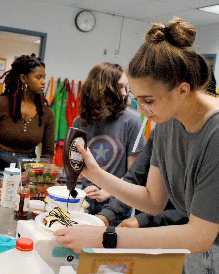 For her finishing touches, Aimee Harrington (24) adds chocolate syrup to her crêpe. Other choices included bananas and strawberries.