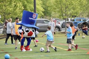 TOPSoccer mascot plays soccer with children and other attendees. Picture taken from Stafford Soccer Facebook page.