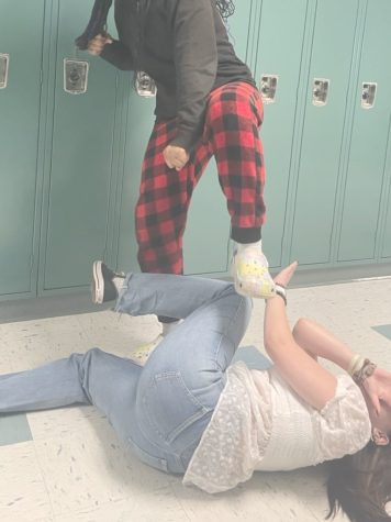 Staged photograph depicting a student kicking down on another student.